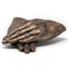 Bronze hands laying on top of each other