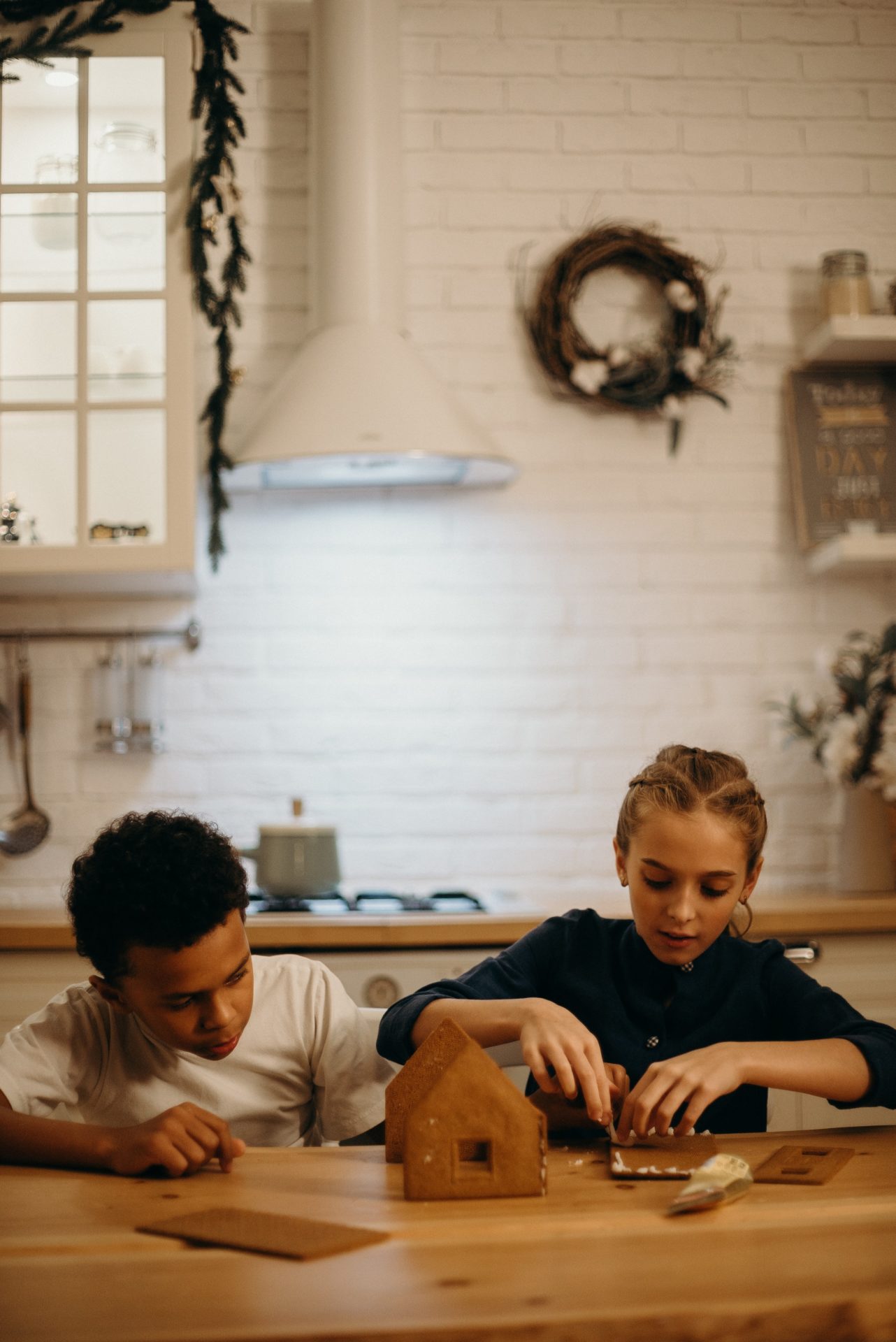 Children building gingerbread house Christmas decoration